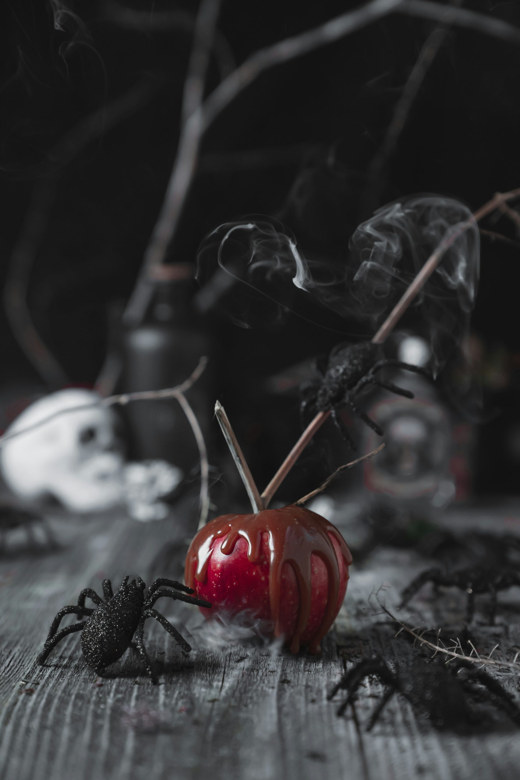 A reflective orange pumpkin sits centered in a spooky backdrop, surrounded by encroaching black spiders and spiderwebs.